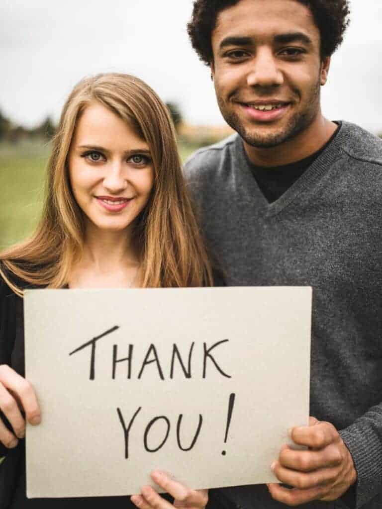 man and woman holding a thank you sign